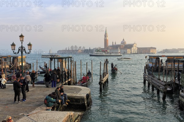Boat dock at St Mark's Square, San Giorgio Maggiore church in the background, evening sky, Venice,