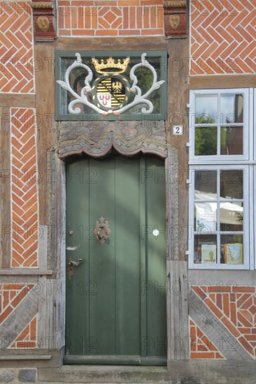 Door with coat of arms and golden crown at the entrance to the Eulenspiegel Museum, half-timbered