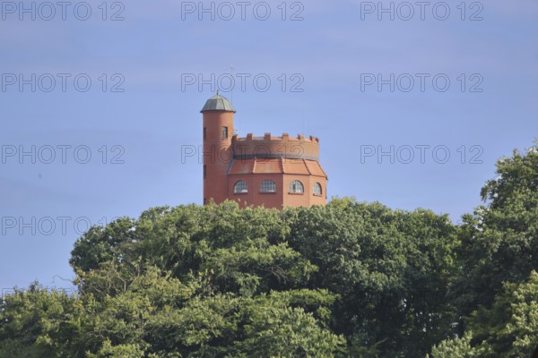 Red water tower with battlements built in 1913, looking out of the forest, spire, Mölln,