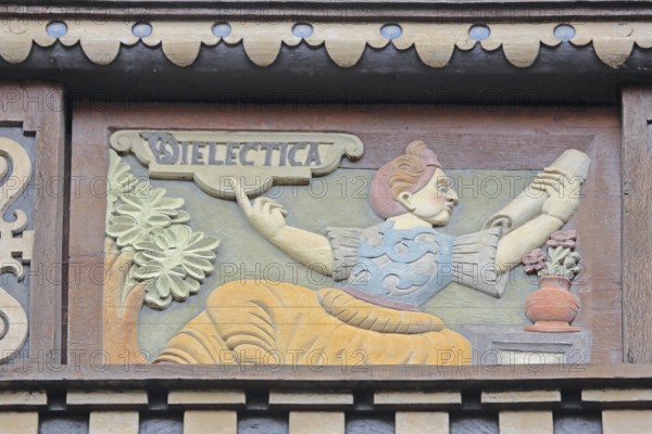 Allegorical woodcarving with figure on dialectics, philosophy, rhetoric talk, conversation, scroll,
