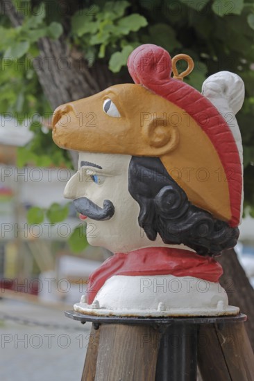 Colourful Swedish head as a landmark, historic wooden head with face and four eyes, tree house, Old