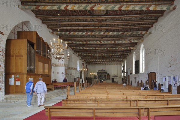 Interior view of the Church of the Holy Spirit with painted wooden ceiling, wooden beams, organ,