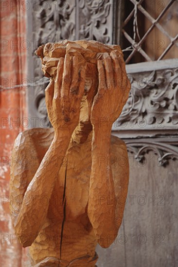 Wooden figure with hands in front of the face, interior view, wooden sculpture, modern art, wood