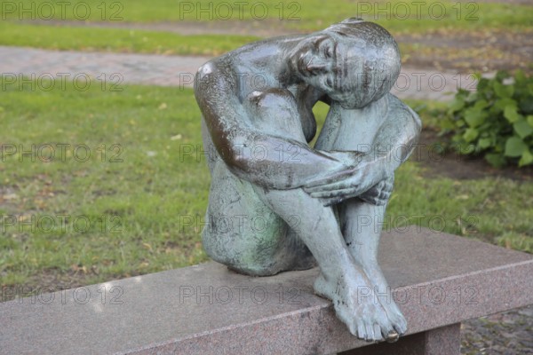 Sculpture Resting by August-Martin Hoffmann 1976, bronze sculpture, seated female figure on bench