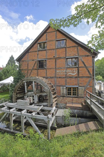 Grinding mill with brick building and water wheel, mill wheel, wooden construction, inscription,