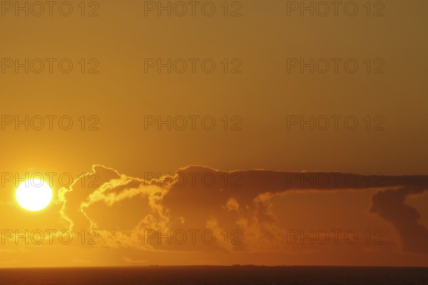 Sunset over the sea with intense orange clouds, crossing between Orkney and Shetland Islands,