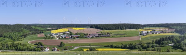 Panorama of a rural landscape with fields and wind turbines under a blue sky, near Böhmenkirch,