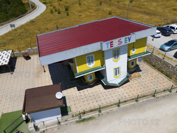 Building with car park against a rural backdrop, aerial view, Ters Ev, upside down house,