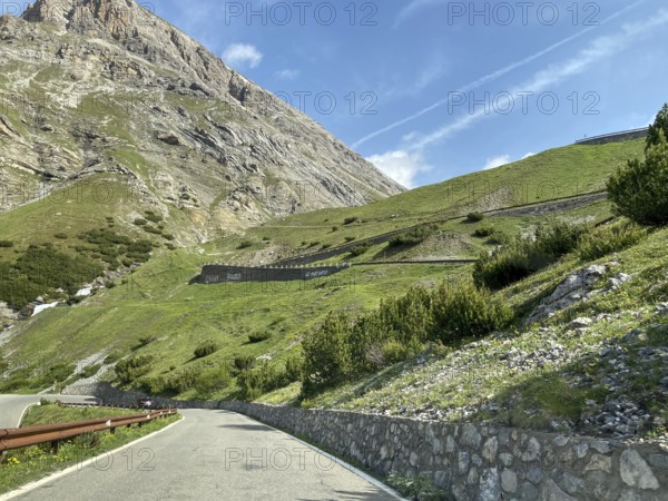 View of the Alpine road in front Mountain road at tree line, in the centre of the picture