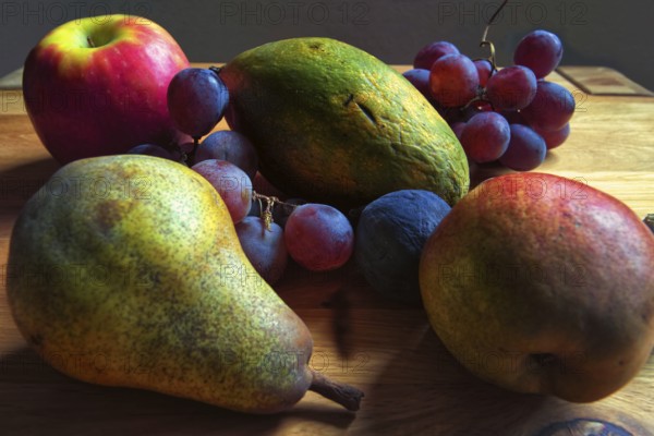 Colourful composition of pears, grapes and apples on a wooden table, Willich, North