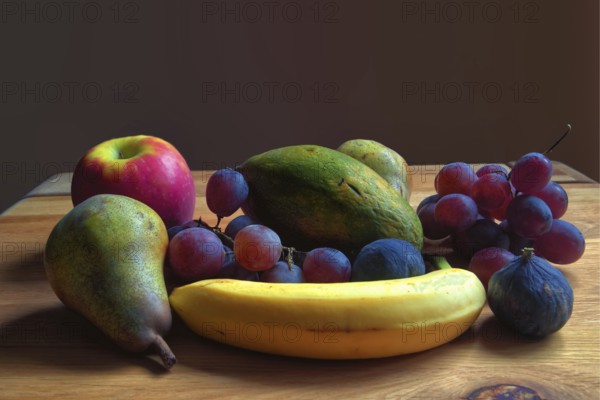Fresh fruit arrangement of pears, grapes and bananas on a wooden table, Willich, North