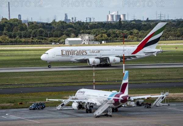 Düsseldorf Airport, Eurowings Airbus aircraft on the apron, Emirates Airbus A380-800 taking off, in