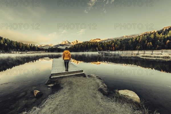 Young woman at Lake Staz near Sankt Moritz in the Engadine in Switzerland. Morning atmosphere with