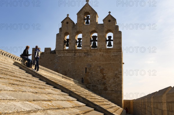 Bell tower of Notre-Dame-de-la-Mer church, two tourists enjoying the view from the roof of the
