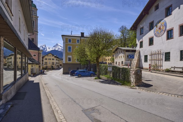 General architecture, historical building, sundial, quarry stone wall, parking boxes, vehicles,