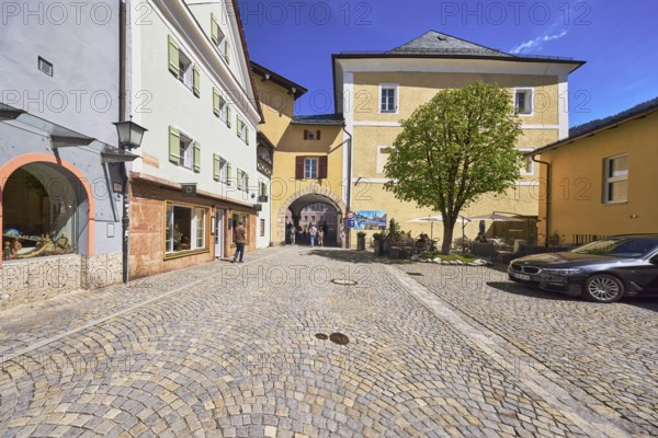 Historic buildings, square, cobblestones, lantern, tree, archway, pedestrian as secondary motif,