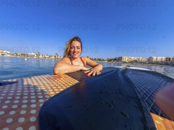 Young woman relaxing on a paddle board, soaking up the sun and enjoying a blissful summer day at