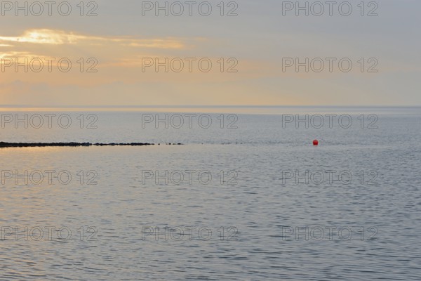 Evening mood at the Wadden Sea, stone groyne with red buoy, North Sea, Norddeich, Lower Saxony,