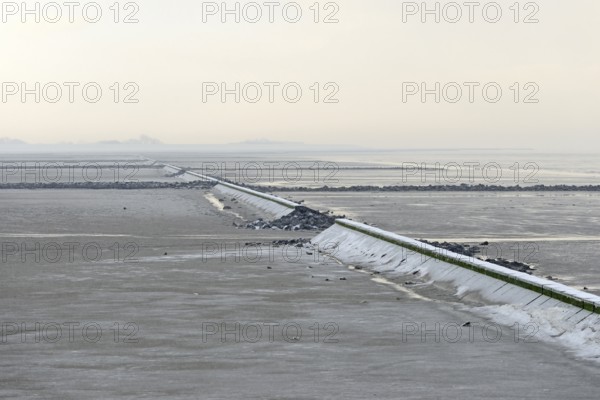 North Sea coast, cloudy winter day, Wadden Sea at low tide, stone groynes as coastal protection,