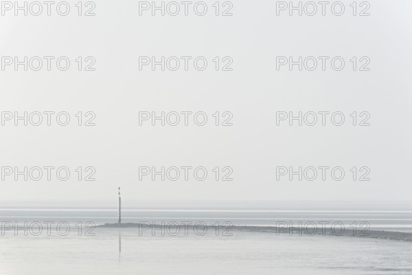 North Sea coast, cloudy winter day, Wadden Sea at low tide, stone groyne with sea mark, North Sea,