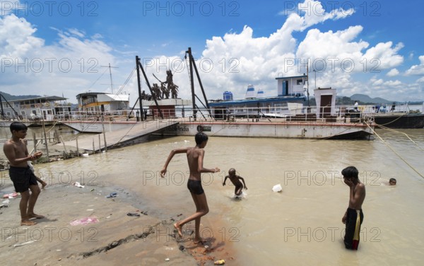 People bathe in the Brahmaputra River to seek relief from the intense summer heat in Guwahati,