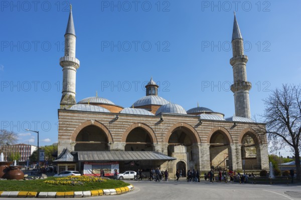 Historic mosque with two minarets on a busy street. The sky is sunny with clear blue. Old Mosque,