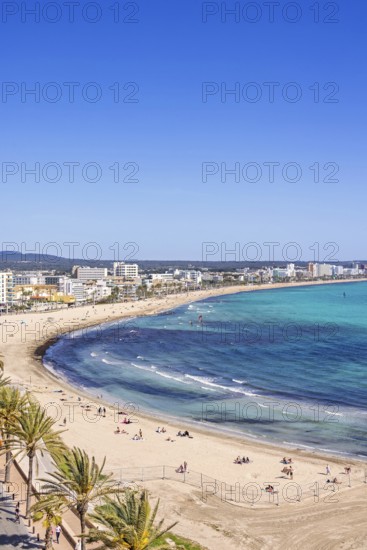 Aerial view at a sand beach with sunbathing tourists by a tourist resort by the sea a sunny summer