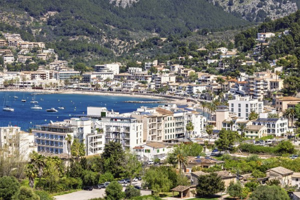 View at a tourist resort by a sea bay by the mountains with houses by the beach a sunny summer day,