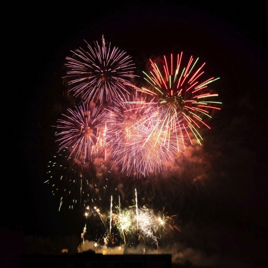 Colorful fireworks burst across the night sky in France, marking the celebration of Bastille Day on