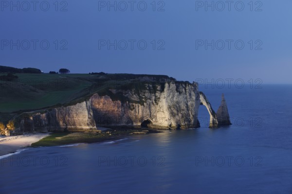Cliffs with the Falaise d'Aval rock gate and the Aiguille d'Etretat rock needle at night, Etretat,