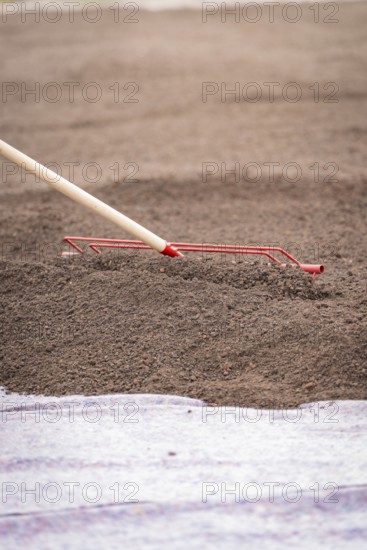 Close-up of a tool spreading soil on a construction site, roof greening, house construction,