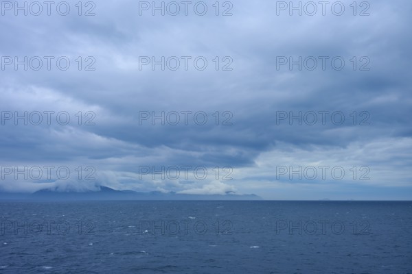 Sweeping views of the sea and distant clouds over the mountains on the horizon, summer, Cook