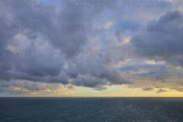 Cloudy sky over a calm, wide ocean at sunset, summer, Nugget Point Lighthouse, Ahuriri Flat, Otago,