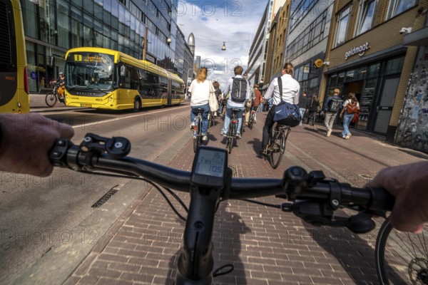 Ride your bike on the central cycle path on Lange Viestraat, Vredenburg, in the city centre of