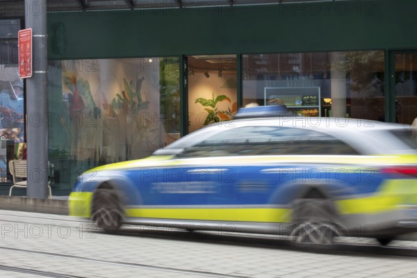 (Photomontage) Passing police car in the city