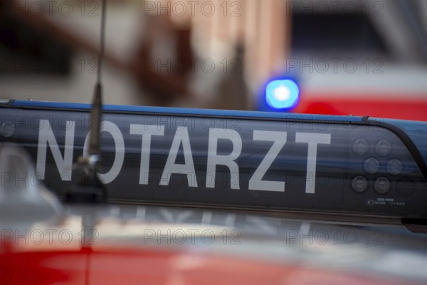 Close-up of an emergency ambulance, flashing blue lights on an ambulance in the background