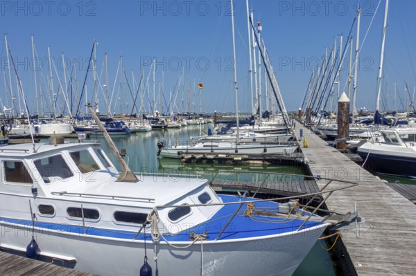 Recreational motorboats and sailing boats moored in marina of fishing village and seaside resort