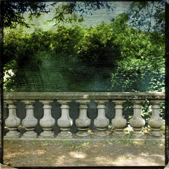 A garden balustrade exhibits a rich textured effect, framed by lush greenery and a captivating view