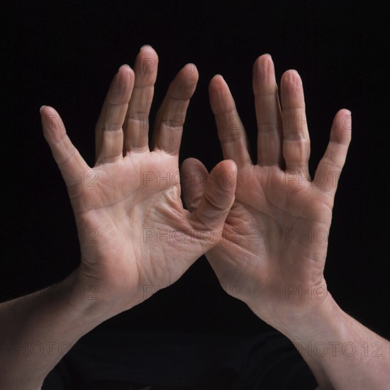Two hands are raised and positioned in a distinctive gesture, highlighting their textures and