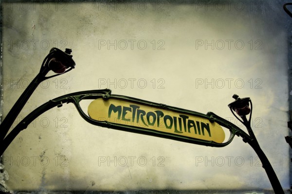Captured from below, the iconic metro sign in Paris highlights its historic charm and significance