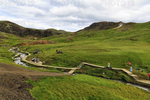 Tourists, hikers bathing in a geothermally heated river, Reykjadalur bathing area, Hveragerði,