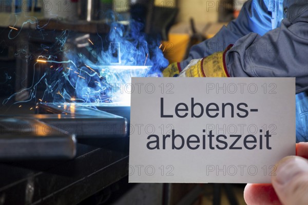 (Photomontage) Business card with the inscription LEBENSARBEITSZEIT in front of a metalworker