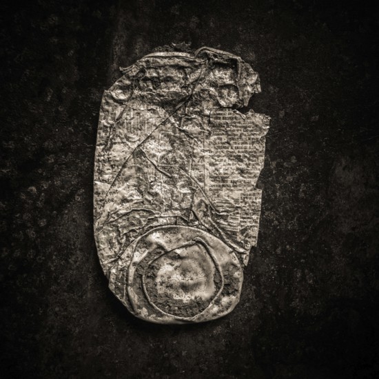 Close-up of a rusty can lying against a dark backdrop highlights the texture and wear of the metal.
