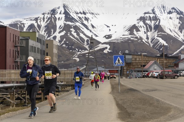 Marathon, group of runners along the city centre, Snow Mountain, Longyearbyen, Spitsbergen,