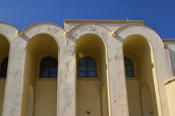 Primary school, Beige-coloured façade with arched windows against a clear sky, Armando Bernabiti,