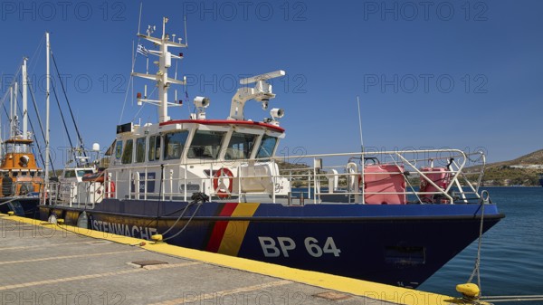 Large patrol boat at the dock in a harbour under a clear blue sky, Frontex. German Coast Guard,