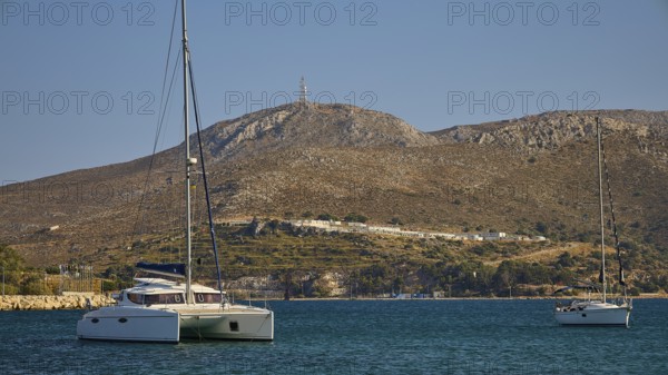 Two sailing boats on a calm sea, with barren hills in the background, Lakki, Leros, Dodecanese,