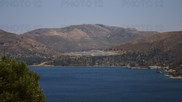 Landscape with mountains behind a blue sea under a clear blue sky, refugee shelter, Lakki, Leros,
