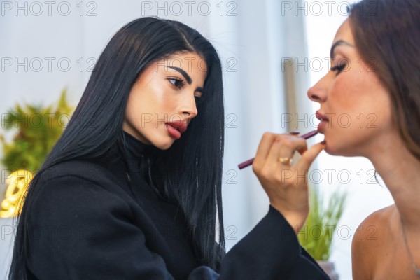 Makeup artist carefully applying lip liner on a client, enhancing her natural beauty in a