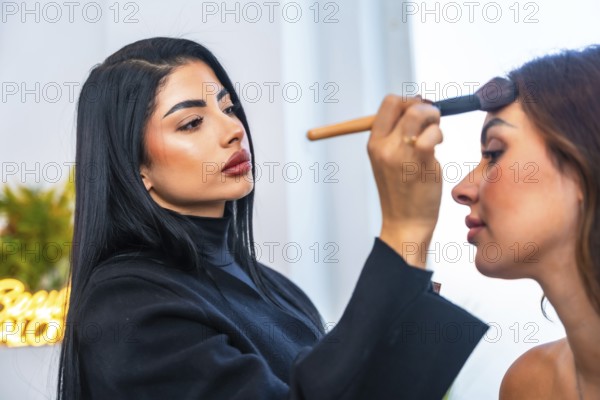 Makeup artist skillfully applying foundation on a client's face in a beauty salon, using a brush